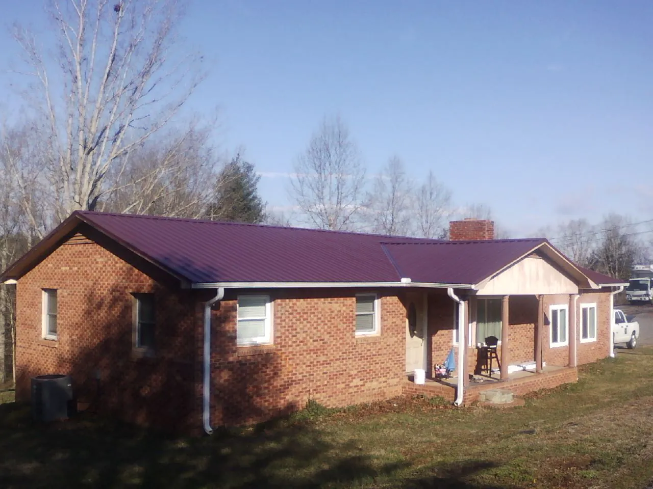 Burgundy metal roof on a brick ranch home with a new addition in Summertown