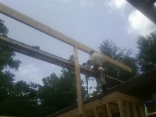 Carpenter setting a ridge beam over a new addition frame — Ice Dam Removal by Roofing Brothers in Summertown