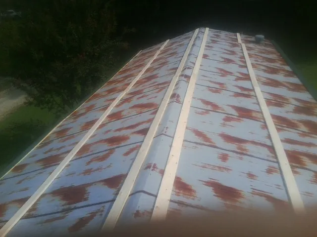 Rusted metal roof panels with new wood purlins before replacement — Storm Damage Roof Repair in Summertown by Roofing Brothers