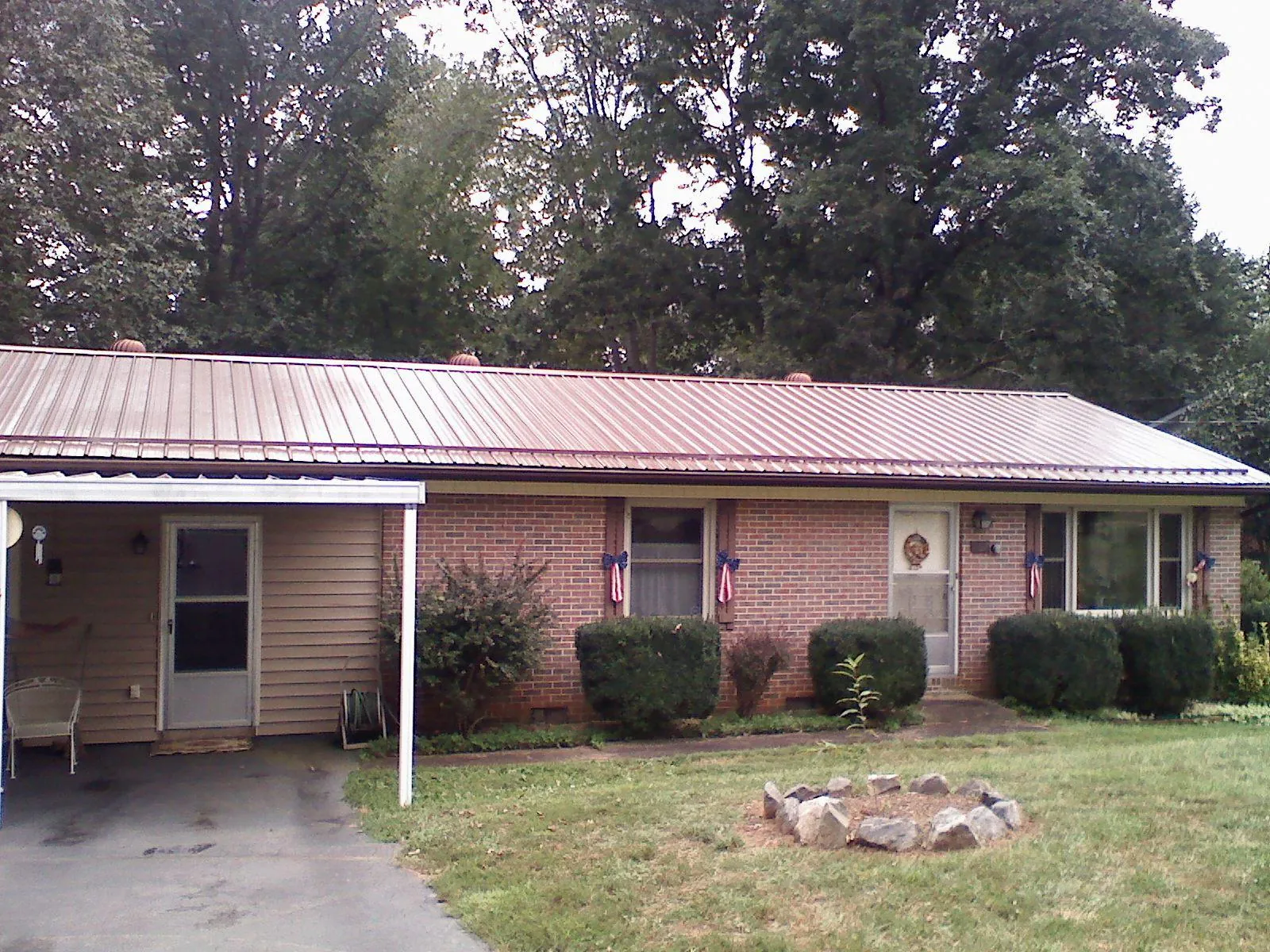 Bronze metal roof and carport on a brick ranch home — Roof Repair work by our crew in Summertown